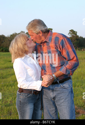 Una buona ricerca coppia matura kissing nel sole del tardo pomeriggio Foto Stock