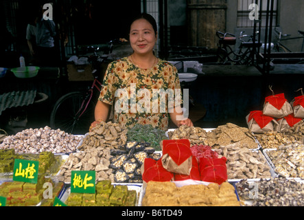 1, una donna cinese, donna musulmana, musulmana, venditore ambulante, vendono dolci, candy, caramelle, il Quartiere Musulmano, Xian, Provincia di Shaanxi, Cina e Asia Foto Stock