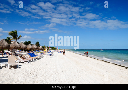 Sedie a sdraio e ombrelloni Playa Mujeres Mexico // PLAYA MUJERES, Messico - sedie a sdraio e ombrelloni di paglia sono disposti sulla spiaggia di sabbia bianca di Playa Mujeres al sole. Questa destinazione turistica si trova sulla costa nord-orientale della penisola dello Yucatan, a circa 10 chilometri (6 miglia) a nord di Cancun. Playa Mujeres è conosciuta per le sue spiagge incontaminate e gli edifici di lusso che hanno trasformato questa zona costiera in una popolare destinazione turistica. La spiaggia fa parte della più ampia regione della Riviera Maya, che si estende lungo la costa caraibica del Messico. La zona si trova Foto Stock