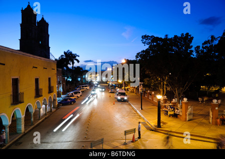 Valladolid Downtown Night Street Scene Yucatan Messico // VALLADOLID, Yucatan, Messico - Una scena notturna nel centro di Valladolid, catturata dal balcone del Municipio. La vista mostra l'architettura coloniale e la vibrante atmosfera di questa storica città dello Yucatecan. Illuminata da luci stradali, la scena raffigura la vita locale e il fascino dell'area centrale di Valladolid, con i suoi edifici colorati, i pedoni e la miscela di cultura messicana tradizionale e moderna. Foto Stock
