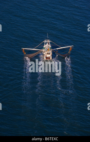 Vista aerea di una barca da gamberetti reti di lavoro interrotta l'acqua al largo di Charleston nella Carolina del Sud Foto Stock