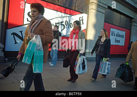 Acquirenti di Londons Oxford street borse e zaini affare di caccia in January Sales Foto Stock