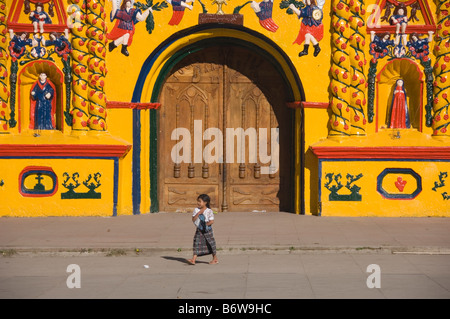 Giovane ragazza di fronte le isole Canarie-giallo chiesa di San Andres Xecul. Guatemala. Foto Stock