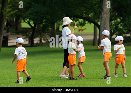 Gli studenti giapponesi giocando in un parco di Nara JP Foto Stock