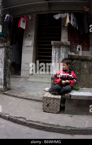 Ragazzo asiatico in attesa nella parte anteriore della casa in Guangzhou Canton Guangdong Cina Asia Foto Stock