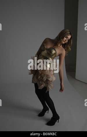 Modello di moda modellazione abito in oro con piume Foto Stock