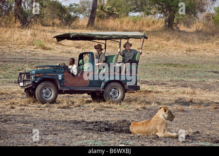 Tanzania, Katavi National Park. I turisti di guardare un orgoglio dei leoni a partire da un veicolo di safari nel Katavi National Park. Foto Stock