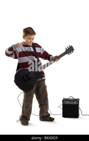 Un ragazzo che sta per colpire una corda su un nero opaco di chitarra elettrica con amplificatore isolato su uno sfondo bianco Foto Stock