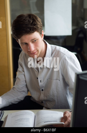 Ragazzo seduto con libro Foto Stock