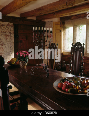 Ferro battuto candelabri in rovere antico tavolo con sedie Tudor travi nel XVII secolo il paese sala da pranzo Foto Stock