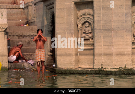 India, Varanasi, uomo che prega nel fiume Gange Foto Stock