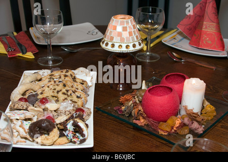 Tavolo realizzato per il cenone di capodanno con gli occhiali, piatto e alcuni dolci. Foto Stock