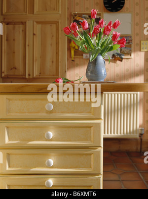 Close-up di tulipani rosa in vaso sulla Credenza con cassetti a crema Foto Stock