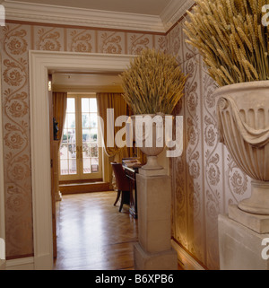 Mais essiccato in urne di pietra su plinti in paese grande hall con carta da parati in seta e aprire lo sportello per la sala da pranzo Foto Stock