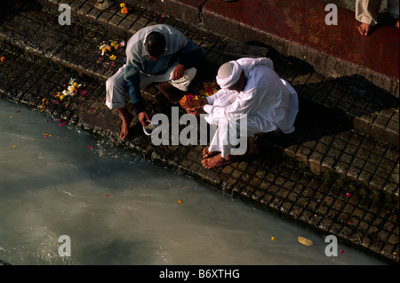 India, Uttarakhand, Haridwar, gente che fa offerte al fiume Gange Foto Stock