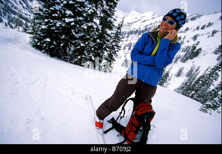 Backcountry femmina sciatore parlando sul suo telefono cellulare in montagna. Foto Stock