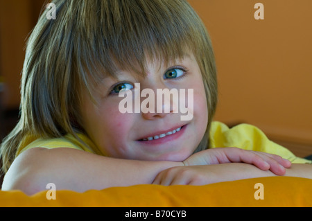 Sorridente dagli occhi luminosi 5 anno vecchio ragazzo con capelli lunghi Foto Stock