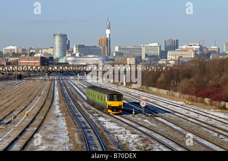 In treno in inverno a Small Heath con Birmingham City center dietro, West Midlands, England, Regno Unito Foto Stock