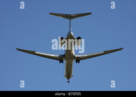 Un commerciale aereo jet, contro un luminoso cielo estivo blu, venuta per un atterraggio in un aeroporto. Foto Stock