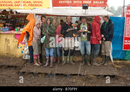 Le persone che la copertura dalla pioggia a Glastonbury Festival 2007 Foto Stock