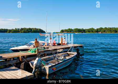 Svezia Stoccolma Stoccolma arcipelago la gente sul molo a guardare il traffico delle barche a GRÄDDÖ Foto Stock