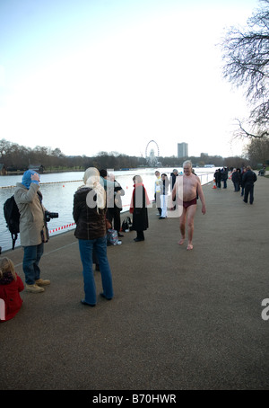 Un coraggioso nuotatore passeggiate per gli spogliatoi dopo una mattina di Natale nuotare nell'Hyde Park di Londra serpentina Foto Stock