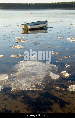 Barca a remi su una baia di Findhorn coperta di ghiaccio Foto Stock