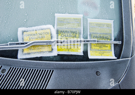 Tre i biglietti per il parcheggio attaccata alla vettura congelati parabrezza della vettura Foto Stock