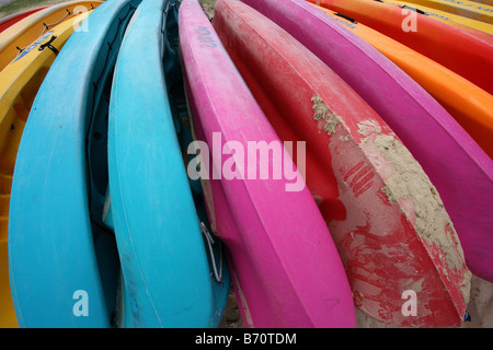 Una fila di vivacemente colorato Canoe sulla spiaggia QUEENSLAND AUSTRALIA ORIZZONTALE11373 BDB Foto Stock