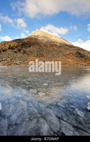 Llyn Ogwen ghiacciato con penna Yr Ol Wen in background. Foto Stock