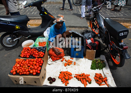 Commerciante di mercato nel mercato di Port Louis Maurizio la vendita di frutta e verdura fuori strada Foto Stock