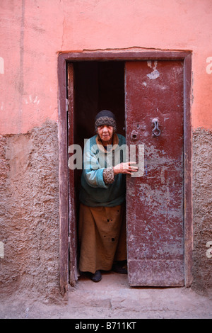 Vecchia donna alla porta nella Medina di Marrakech, Marocco Foto Stock