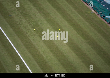 3 palle da tennis si stese sull'erba, aspettando che un ragazzo di palla li raccolga dal lato del campo numero 1, Wimbledon Foto Stock