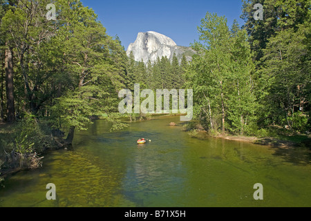 CALIFORNIA - Mezza Cupola che sovrasta la rafters galleggiando giù il fiume Merced attraverso il Parco Nazionale di Yosemite Valley. Foto Stock