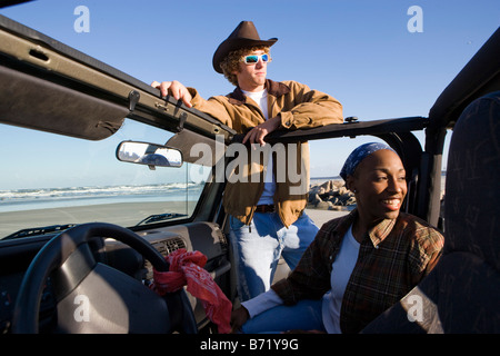 Giovani interracial giovane con jeep a beach Foto Stock