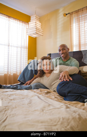 Felice interracial afro-americano di origine ispanica giovane rilassante sul letto Foto Stock