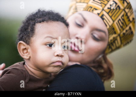 African American madre vestita nei tradizionali costumi africani figlio di contenimento Foto Stock