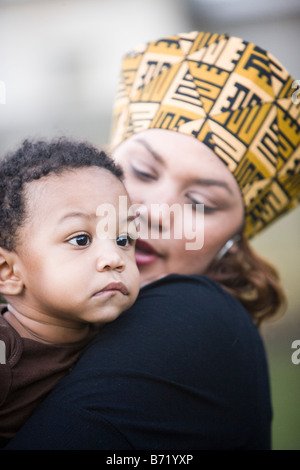 African American madre vestita nei tradizionali costumi africani figlio di contenimento Foto Stock