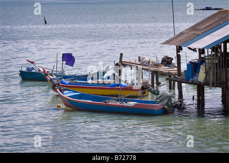 Barche da pesca legato accanto a un tipico plank pier e Fisherman's shed Penang Malaysia Foto Stock