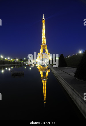 La torre Eiffel illuminata di notte e si riflette in un stagno di Parigi, Francia. Foto Stock