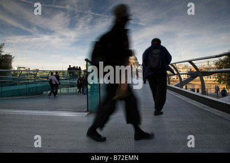 I pedoni a piedi attraverso il Millennium Bridge con la Cattedrale di St Paul e nella distanza di Londra, Inghilterra. Foto Stock