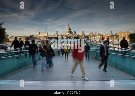 I pedoni a piedi attraverso il Millennium Bridge con la Cattedrale di St Paul e nella distanza di Londra, Inghilterra. Foto Stock