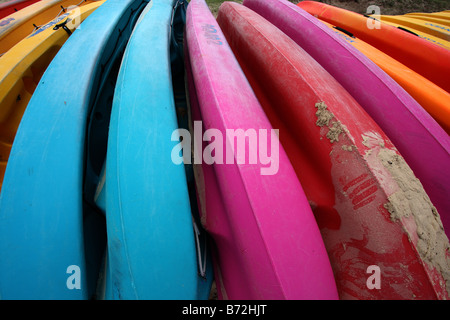 Una fila di vivacemente colorato Canoe sulla spiaggia QUEENSLAND AUSTRALIA ORIZZONTALE11374 BDB Foto Stock