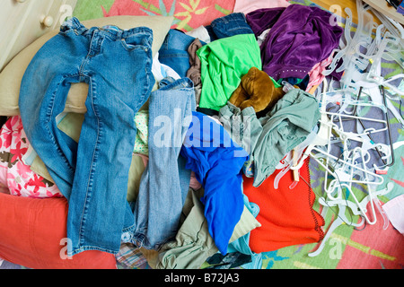 Un mucchio di vestiti sul pavimento in un adolescente la camera da letto. Foto Stock