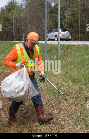 La contea di lavoratore di utilità preleva cucciolata a fianco di autostrada Foto Stock