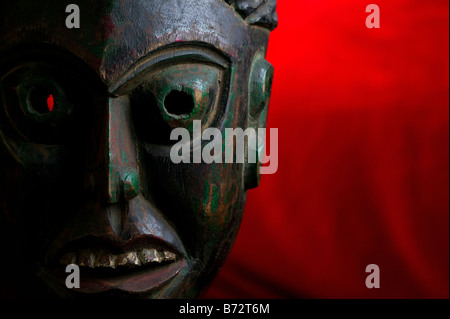 Maschera tribale su uno sfondo rosso Foto Stock