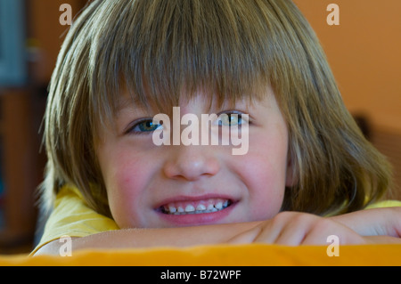 Sorridente dagli occhi luminosi 5 anno vecchio ragazzo con capelli lunghi Foto Stock