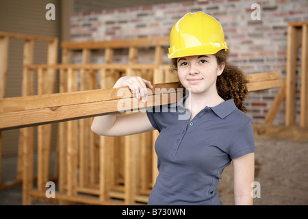 Un giovane apprendista femmina lavorando su un sito in costruzione Foto Stock