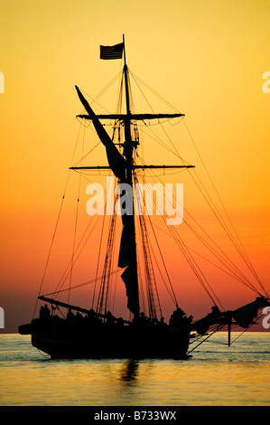 Gli amici di buona volontà a tall ship in un drammatico sul Lago Michigan tramonto Foto Stock