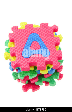 Vista dall'alto di una pila di alfabeto blocchi puzzle su sfondo bianco Foto Stock